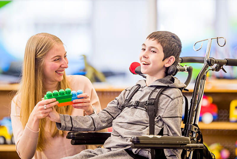 A child with Cerebral Palsy playing with a lady