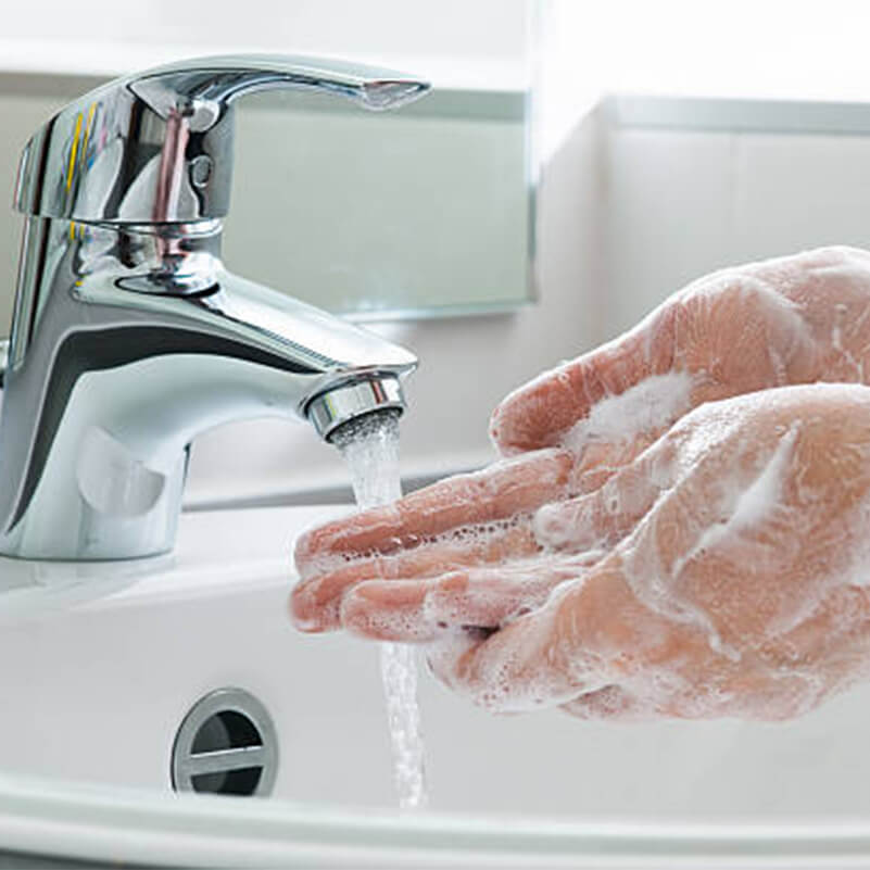 A Human washing his/her hands with soap and water