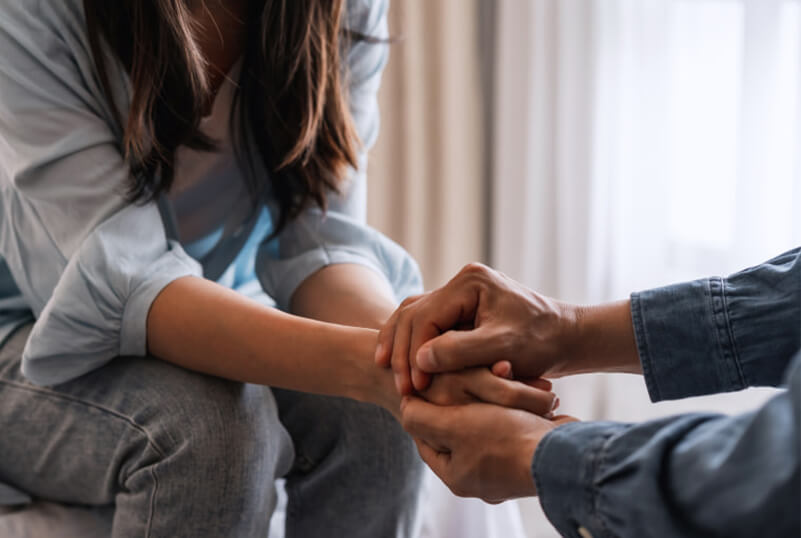 Two persons holding hands